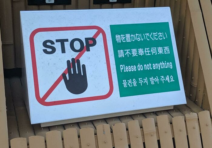 A sign with "STOP" text in a "cancel" logo of an upheld hand. There is text on the side in a number of ideogrammatic languages, and a line in English: "Please do not anything".