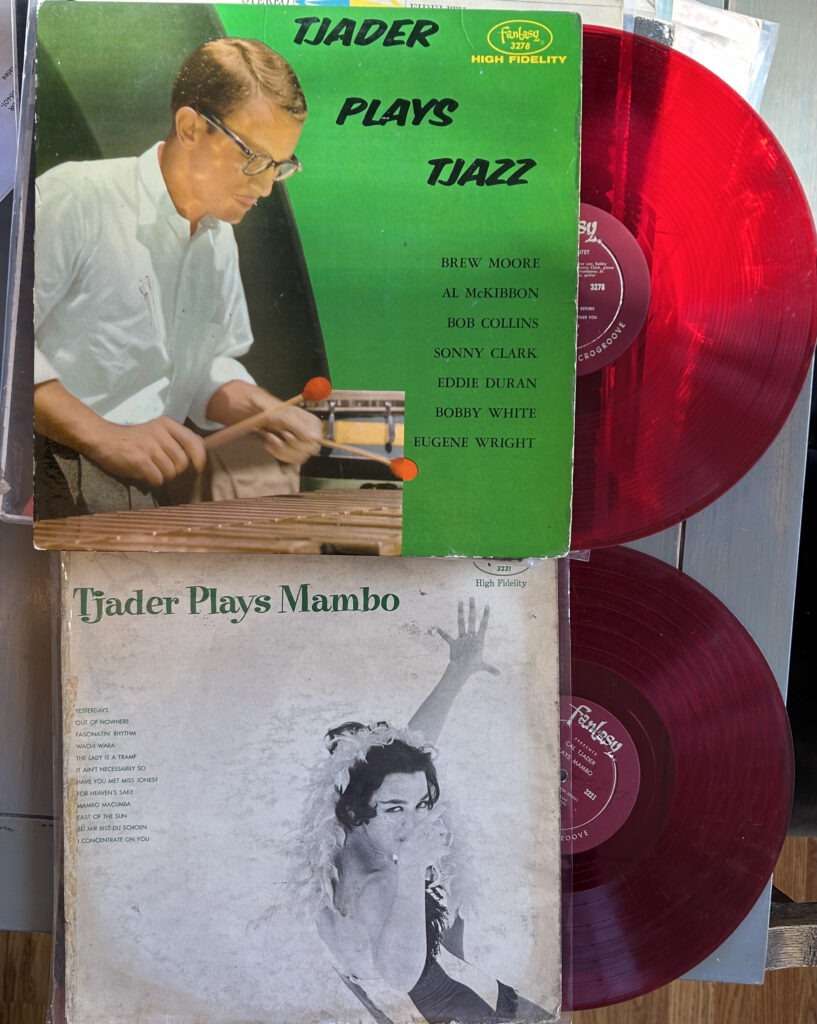 Photo of two red vinyl records, half-emerged from their sleeves: TJADER PLAYS TJAZZ (1954) and TJADER PLAYS MAMBO (1956).